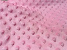 a pink blanket with white polka dots on it