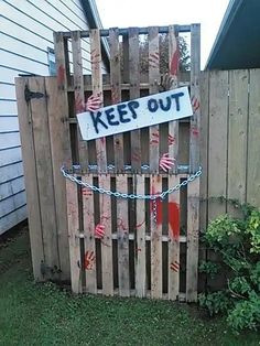 a wooden fence with a sign that says keep out