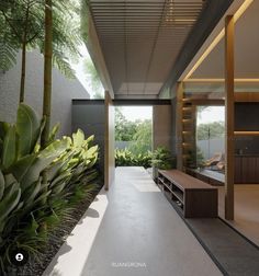 the interior of a modern house with large plants and trees in front of the entrance