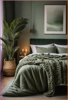 a bed with green blankets and candles in the corner next to a painting on the wall