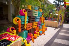 brightly colored wooden benches lined up along the side of a building with decorations on them