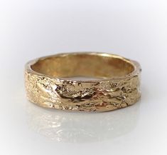 a gold wedding band that has been made to look like it is in the woods