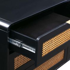 a close up of a black desk with drawers and wicker panels on the bottom