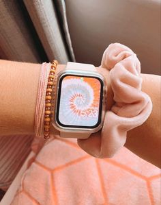 a person wearing a watch on their wrist with a pink flowered band around it