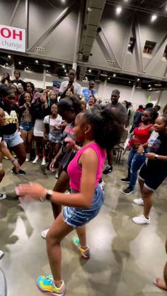 a group of young people dancing in a large room