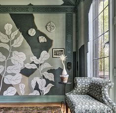 a living room filled with furniture and a painting on the wall next to a window