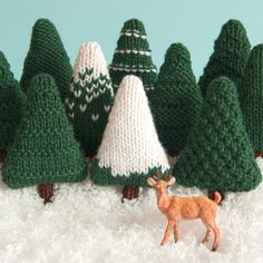 small knitted christmas trees and a deer in the snow