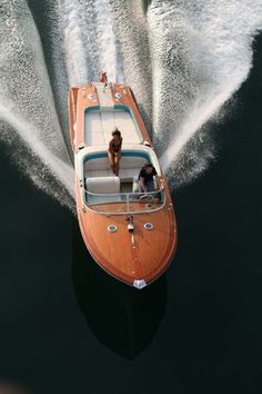 a small motor boat speeding through the water with a man on it's back