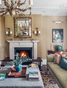 a living room filled with furniture and a fire place under a mirror on the wall