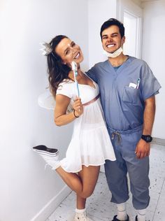 a man standing next to a woman brushing her teeth