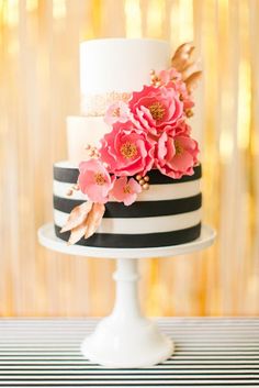 a white and black striped cake with pink flowers on the top is featured in instagram