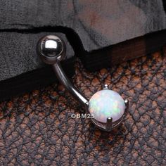 Add a touch of color to your belly button piercing with our Fire Opal Prong Set Belly Button Ring! Made of durable steel, this basic belly ring features a vibrant fire opal stone, perfect for a simplistic yet stylish look. Upgrade your belly ring collection now! * Material: 316L Stainless Steel * Bar Size: 14 GA (1.6mm), 10mm (3/8") * Length: 0.8 inch (21mm) * Width: 0.2 inch (6mm) Suitable for * Navel Piercings It is always recommended to know your exact piercing size to ensure fitment, safety, Navel Piercing, Stainless Steel Bar, Belly Button Ring, Belly Button Piercing, Button Ring, Belly Ring, Belly Rings, White Opal, Blue Rings