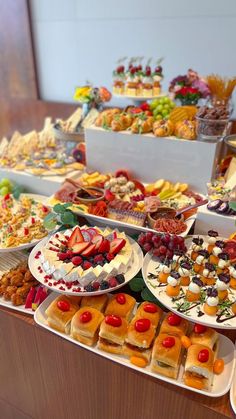 an assortment of desserts and pastries are on display at a buffet style table