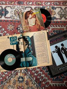 an old record player and some records on a rug