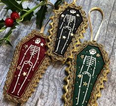 three decorated christmas ornaments sitting on top of a wooden table