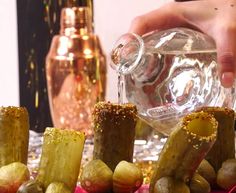 a person is pouring something into some kind of glass jar with food in it on a table