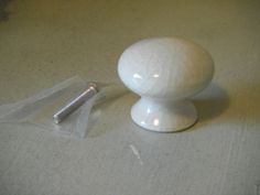 a small white object sitting on top of a table next to a piece of plastic