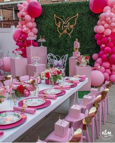 a table set up with pink balloons, plates and napkins for a princess birthday party