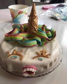 a cake with an ice cream cone on top and some decorations around the edges, sitting on a table