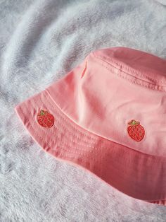 "Kawaii strawberry bucket hat! This strawberry bucket hat is a Magical Girl Bella original art and design, featuring 10 super cute strawberry drawn by my sister and then embroidered onto the hat.  Please note the pink color of the bucket hat may vary depending on lighting, computer / phone screen, and etc. Bucket Hat Inside circumference: approximately 23\" Standard adult hat size This listing has limited quantity that are ready to ship. **MORE DESIGNS AVAILABLE ON MY WEBSITE MAGICALGIRLBELLA.SQ Strawberry Vibes, Strawberry Bucket Hat, Strawberry Drawing, Custom Bucket Hats, Kawaii Strawberry, Strawberry Girl, Embroidered Bucket Hat, Merch Ideas, Pink Strawberry