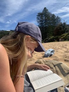 a woman reading a book on the beach