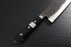 a large knife sitting on top of a black table