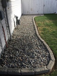 a gravel path next to a white house