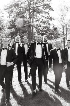 a group of men in tuxedos are walking together