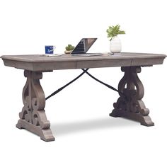 a laptop computer sitting on top of a wooden table next to a vase with flowers