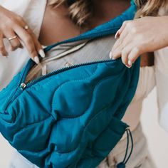 a woman holding a blue purse in her hands