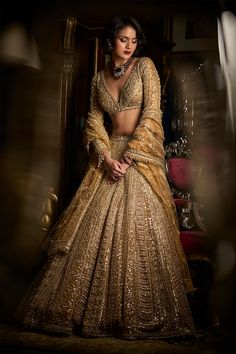 This lehenga set features heavy gold embroidery in a linear pattern. The full sleeves blouse has a plunging neckline. The lehenga set shows delicate pearl, gold beaded detail at the neckline, waist and wrist. It is paired with a fully embroidered dupatta. DELIVERY TIMEPlease allow 8-12 weeks for your outfit to arrive. FABRIC DETAILSLehenga - Net / Dupatta - Net Professional cleaning only. Beaded Lehenga, Scallop Dupatta, Maroon Dupatta, Seema Gujral, Gold Lehenga, Crystal Work, Pengantin India, Full Sleeve Blouse, Crystal Embroidery