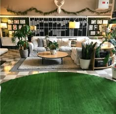 a living room filled with lots of furniture and plants