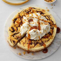 a cheesecake topped with whipped cream and caramel drizzle