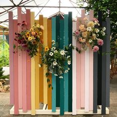 colorful wooden fence with flowers hanging on the top and bottom panels painted multicolored