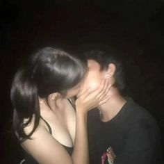 a man and woman kissing in the dark