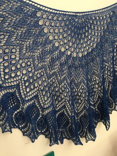 a blue lace shawl hanging on a wall