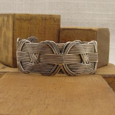 "Handmade sterling silver wire cuff bracelet. The inside measures 7\" including the 1 3/16\" opening. 1\" wide. 18 strands of wire are held together by a decorative wovern vertical pattern. Tested and verified to be sterling silver. Good condition. Unique bracelet. SBT-5" Handwoven Cuff Bangle Bracelet As Gift, Handwoven Bangle Cuff Bracelet As Gift, Artisan Silver Bangle Hand Wrapped, Adjustable Interwoven Bracelets As Gift, Artisan Hand-wrapped Silver Bangle, Artisan Silver Hand Wrapped Cuff Bracelet, Artisan Hand Wrapped Silver Cuff Bracelet, Artisan Hand-wrapped Silver Cuff Bracelet, Elegant Handwoven Silver Jewelry