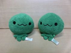 two green stuffed animals sitting next to each other