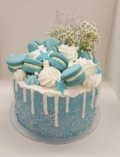 a blue cake with white frosting and stars on top is decorated with baby's breath