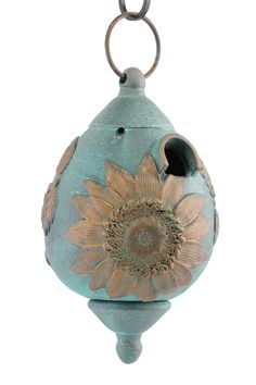 a blue vase with a sunflower painted on the front and bottom, hanging from a chain