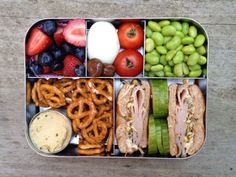 a bento box filled with different types of food and pretzels on the side