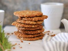 a stack of oatmeal cookies sitting on top of a table next to a cup and saucer