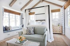 a bedroom with white walls and wood beams