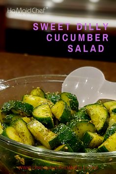 a glass bowl filled with cucumber salad on top of a wooden table