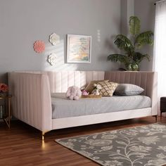 a white day bed sitting on top of a hard wood floor next to a window