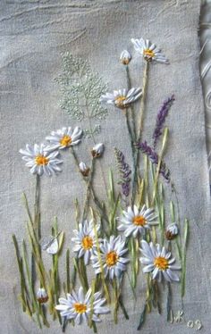 some daisies and other flowers on a table cloth