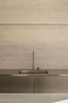 a stainless steel kitchen sink in front of a wall