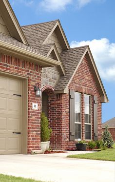 a brick house with two garage doors and windows