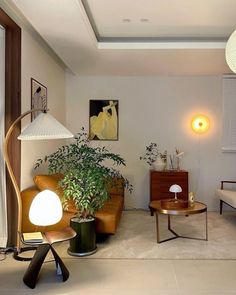 a living room filled with furniture and a lamp on top of a wooden table next to a window