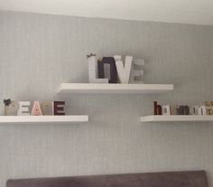 two white floating shelves above a bed in a bedroom